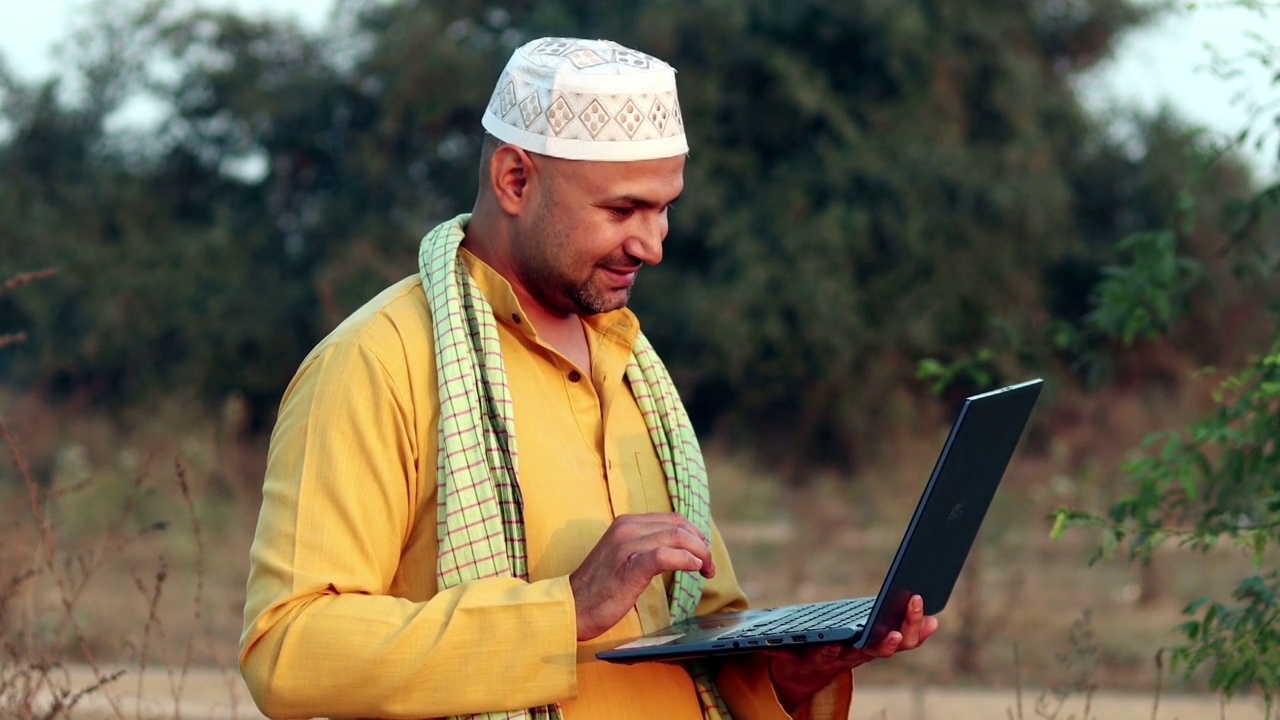 年轻的印度穆斯林男子在户外使用笔记本电脑视频素材