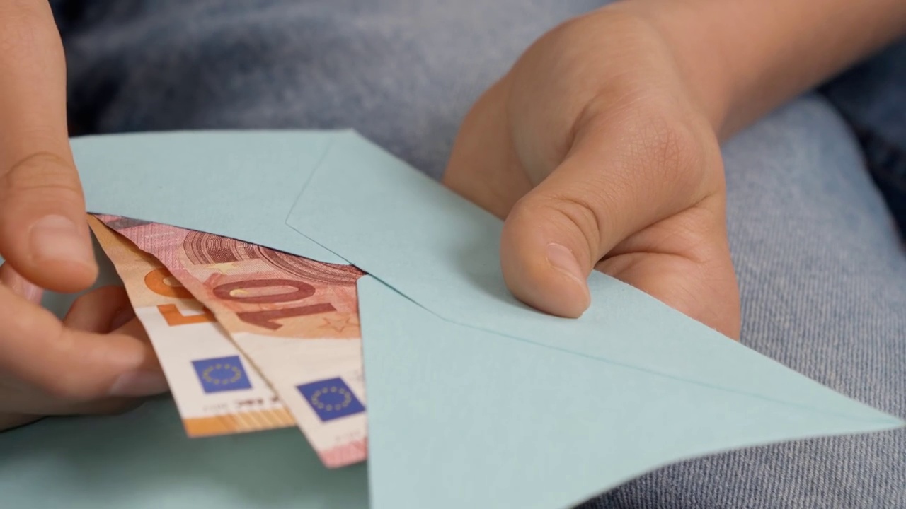十几岁的男孩打开蓝色信封，检查，数了数几张欧元钞票。为孩子们准备礼物、储蓄、理财知识视频素材