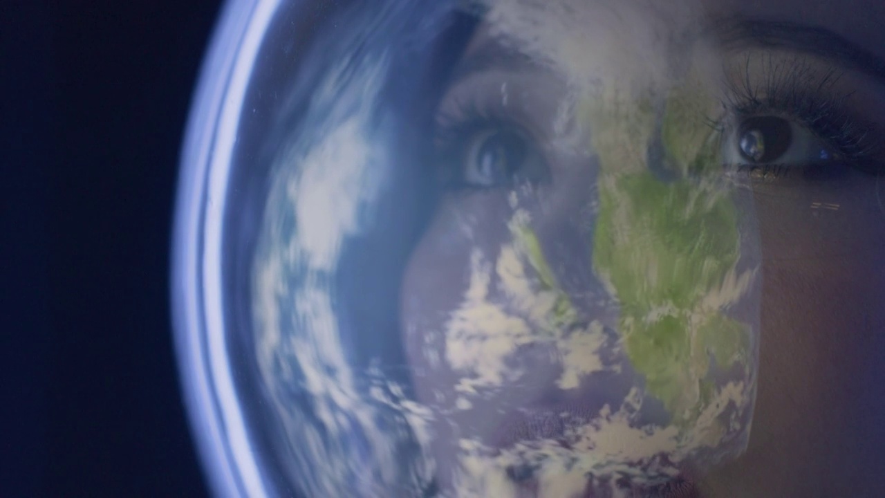 快乐微笑的女宇航员戴着头盔看着地球地球仪视频下载