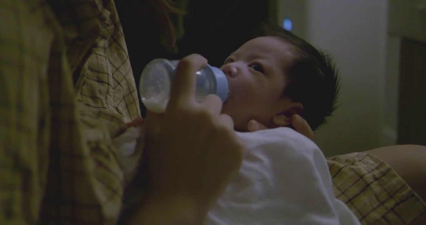 亚洲新生儿在深夜喝牛奶。视频下载