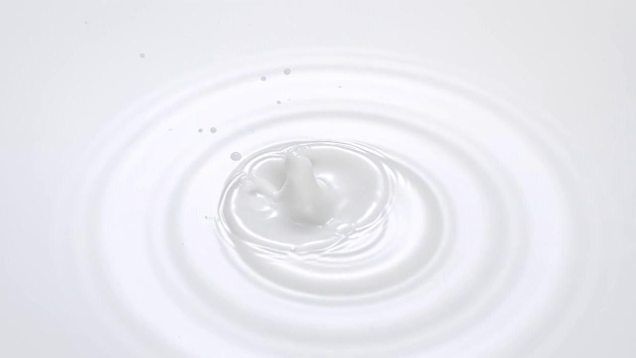 特写镜头和超慢动作与头顶的视图牛奶滴不断下降到一个白色的液体池，使涟漪和皇冠视频素材