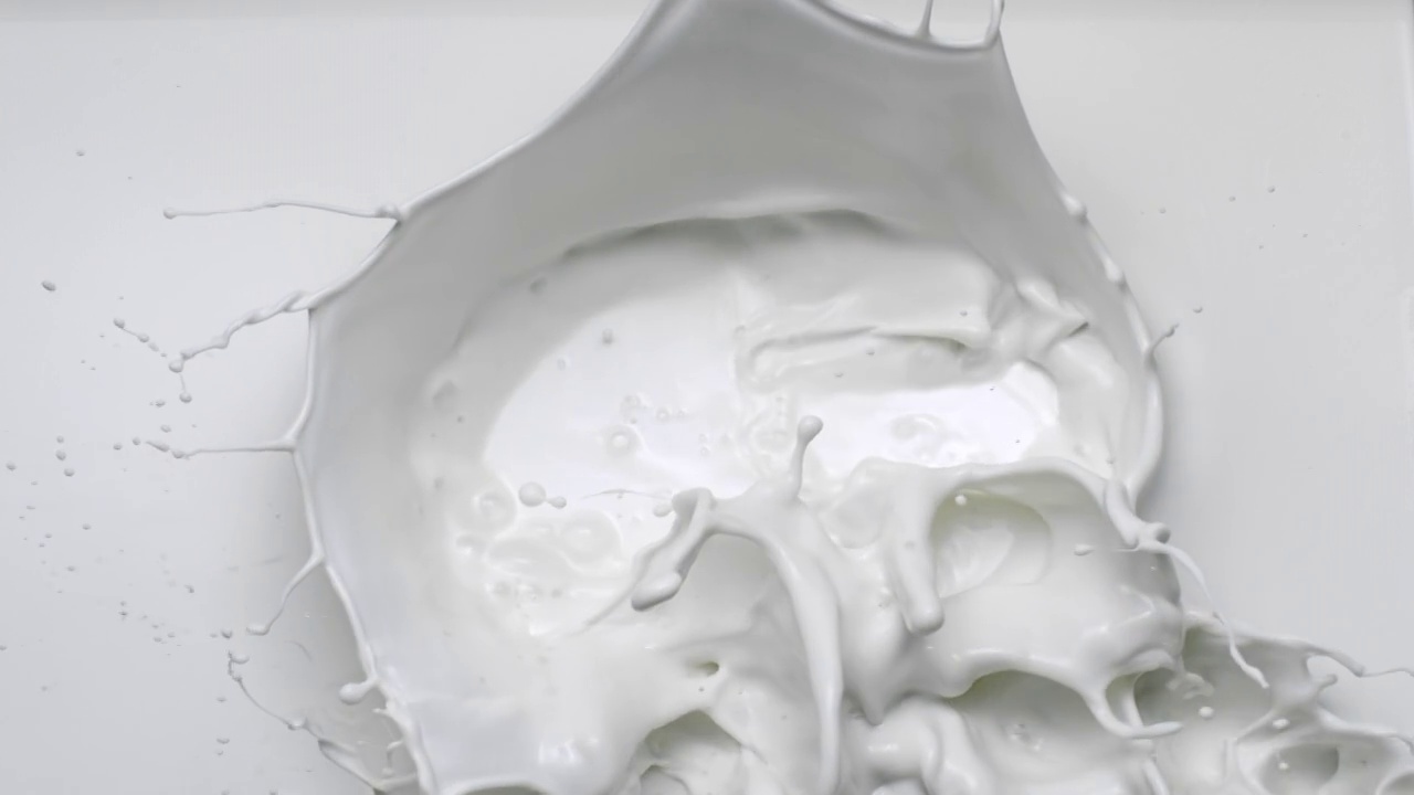 超慢镜头和俯视图特写，将白色液体扔进牛奶池，在画面上溅起水花视频素材
