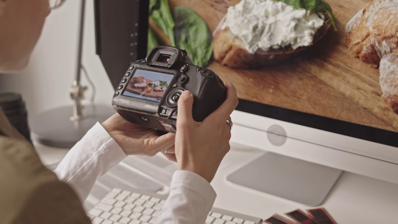 女食物摄影师在相机上滚动照片视频下载
