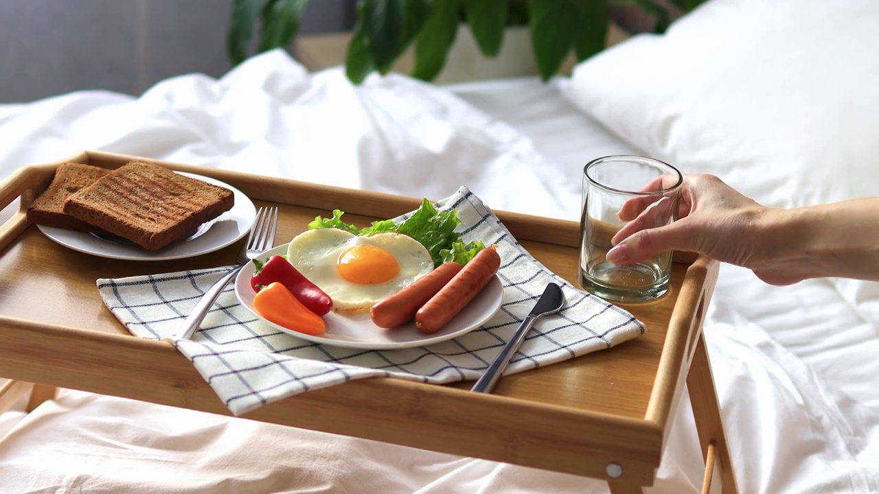 早餐放在床上的托盘上。早....心形煎蛋配蔬菜。视频下载