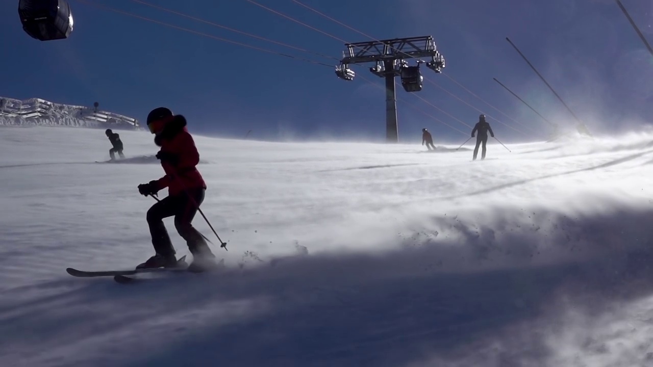 阳光滑雪坡和暴风雪上的滑雪者。慢动作视频下载