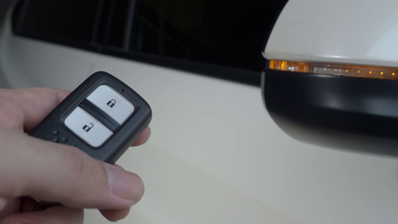汽车钥匙遥控。通过汽车钥匙遥控对汽车进行上锁和开锁。当车门打开或关闭时，按下车钥匙的按钮，车灯就会闪烁。手动使用遥控键。视频素材