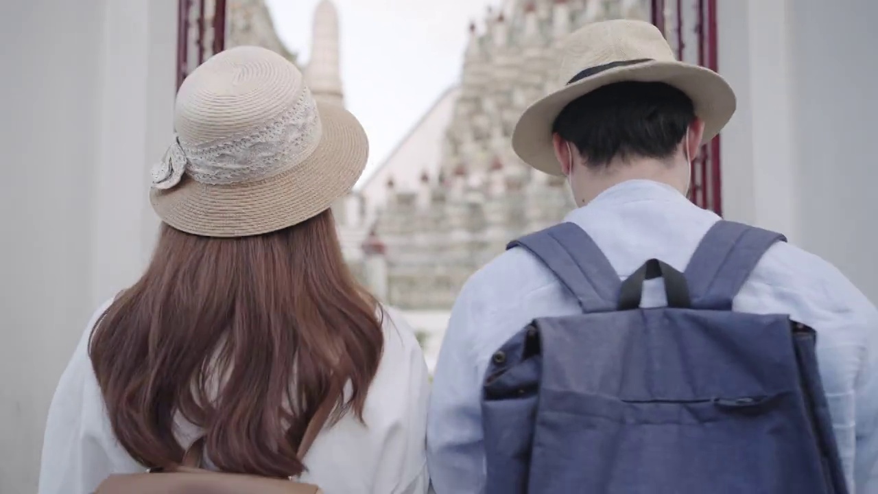 亚洲夫妇快乐的游客旅游，他们的假期和举行在泰国曼谷的阿伦寺视频购买
