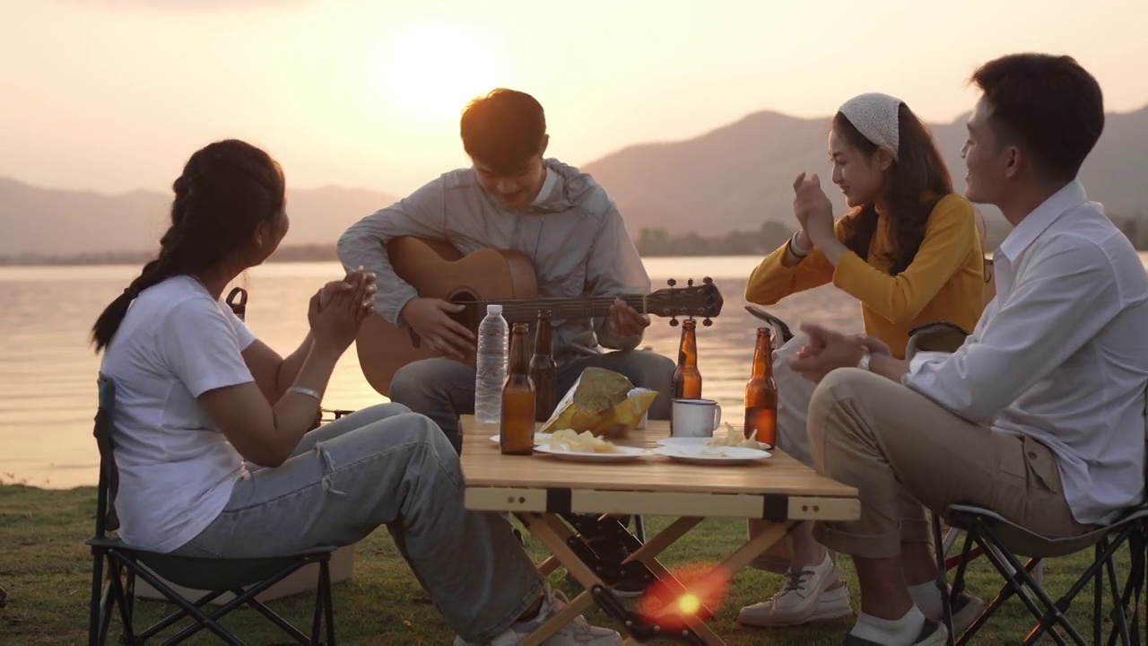 快乐的亚洲朋友团弹吉他和唱歌享受露营视频下载