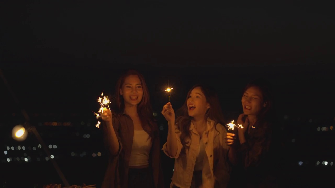 亚洲的年轻女人在晚上拿着烟火玩派对视频下载