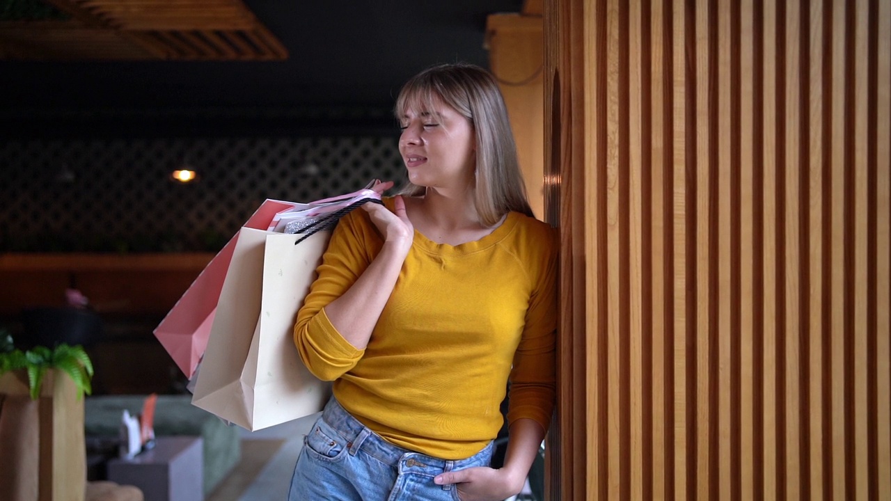 一个现代和快乐的白人妇女的肖像，带着一个购物袋在机场休息室视频下载