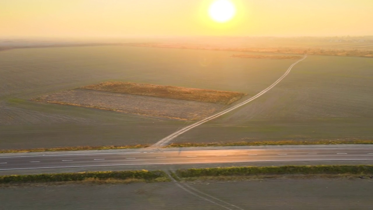 鸟瞰图的城际道路与快速驾驶的汽车在日落。俯视图从无人机公路交通在晚上视频素材