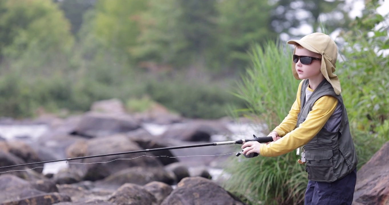 可爱的红发男孩在魁北克的河里钓鱼视频素材