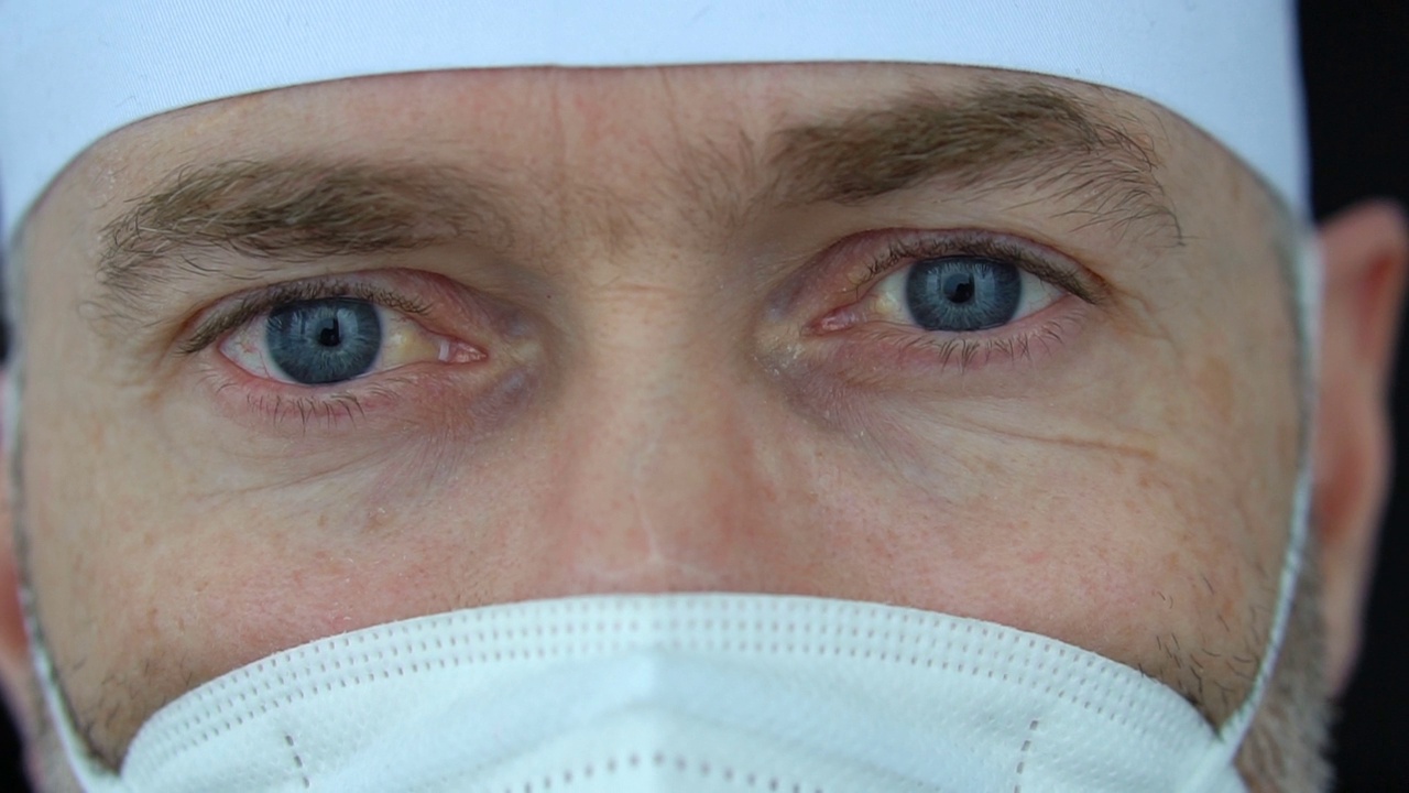 疲惫严重的成熟男性专业医生带着口罩、眼镜和防护服，接走了大量因冠状病毒疫情而感染的患者视频素材