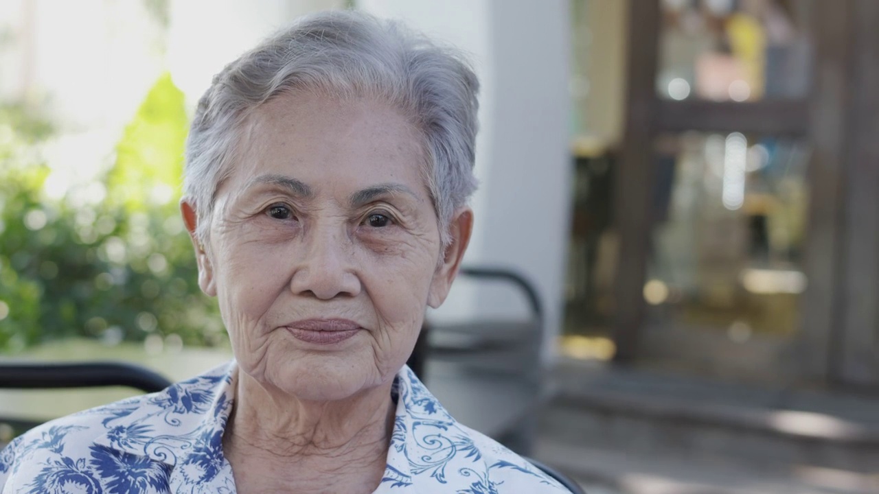 近4K户外亚洲老年女性(80岁女士)美丽的灰色头发，皱纹皮肤和自然的笑脸，表达了对退休生活的情绪积极和快乐。视频素材
