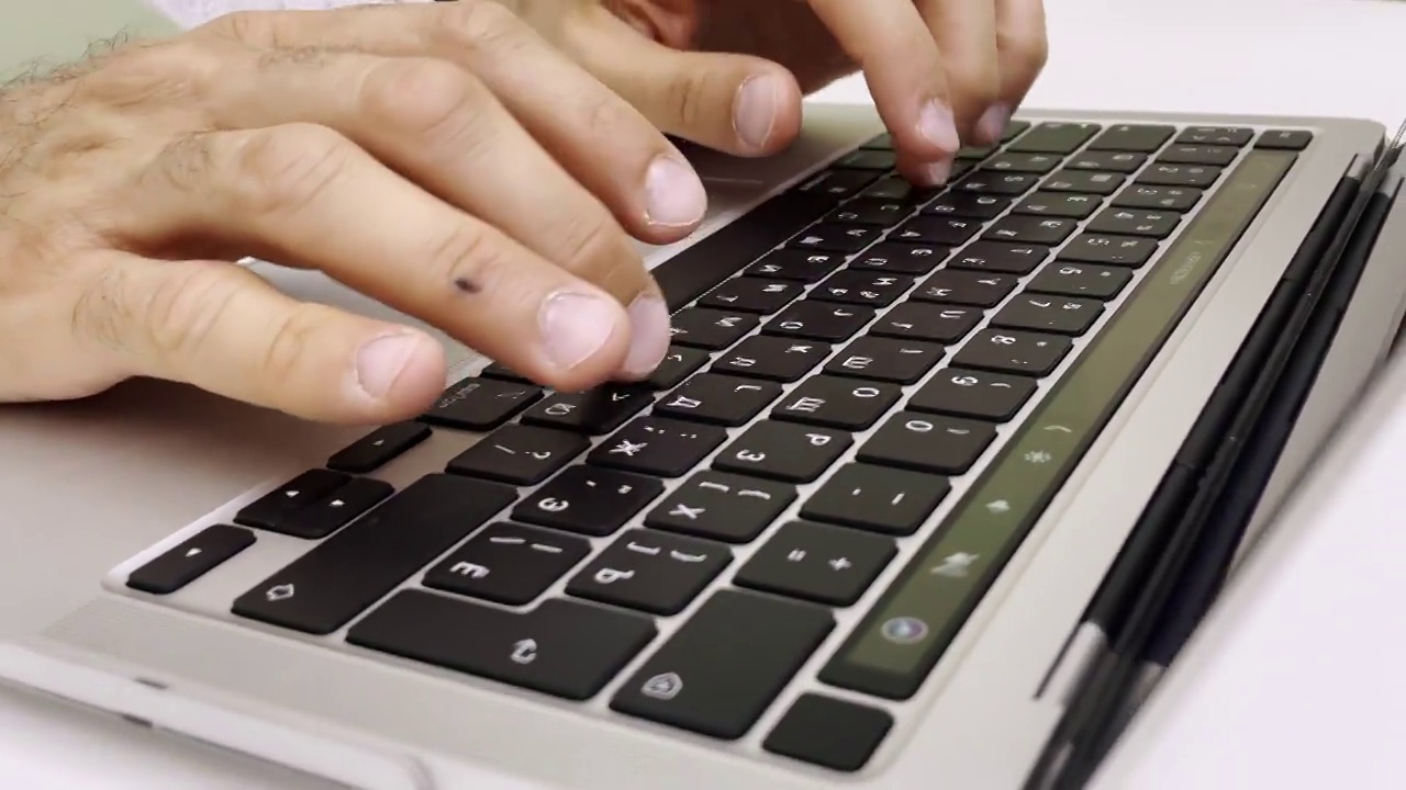 商人在白桌的笔记本电脑键盘上打字视频素材