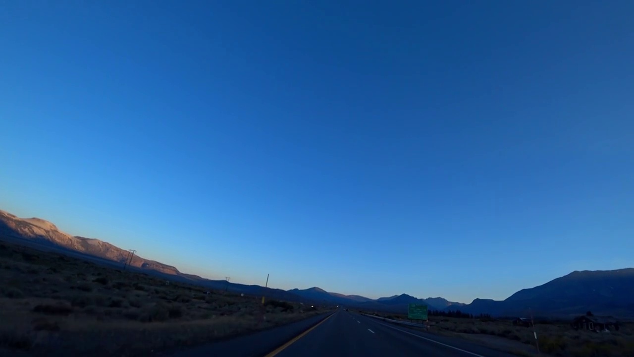 晚上在美国平坦的道路上开车。几乎空无一人的道路。在山的地平线上视频素材