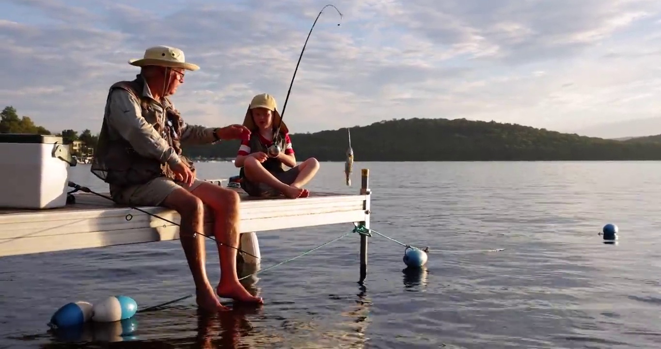 爷爷和孙子在夏天夕阳下钓鱼视频下载