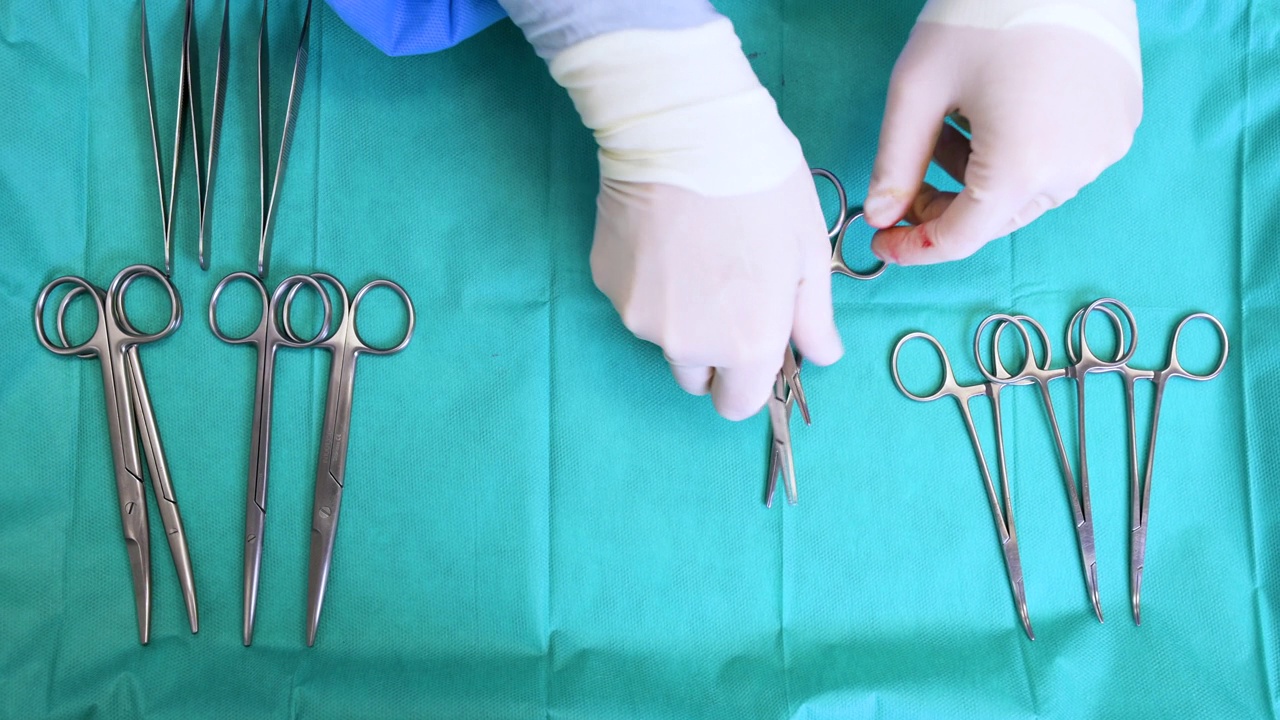 上图蓝色表显示多种手术器械。外科医生从手术台上取下手术工具。高质量4k镜头视频素材