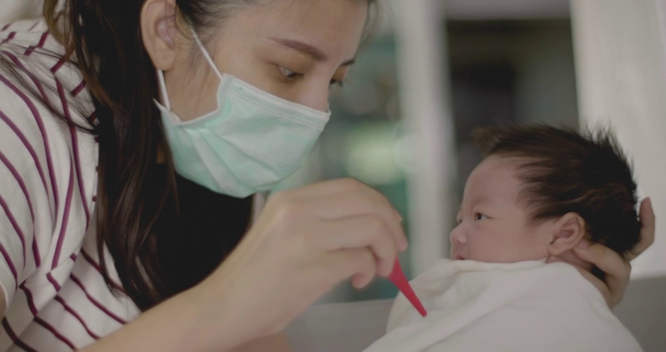 亚洲生病的新生儿有一个流鼻涕，必须被吸出来。视频下载