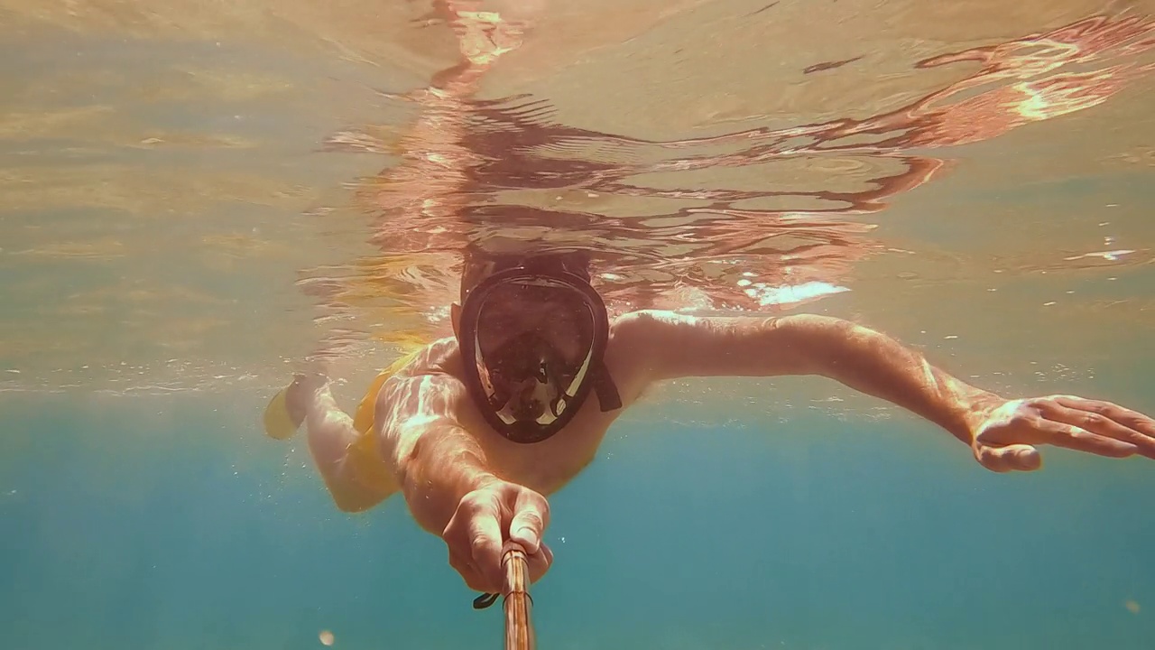 一名男性潜水员在水下对着相机自拍。水下浅水拍摄视频下载