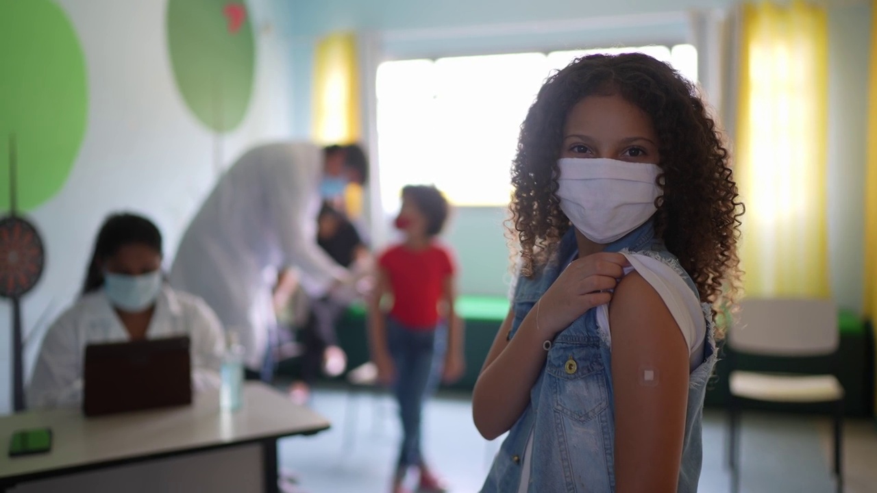 接种疫苗后，一个小女孩展示她的手臂的肖像视频素材