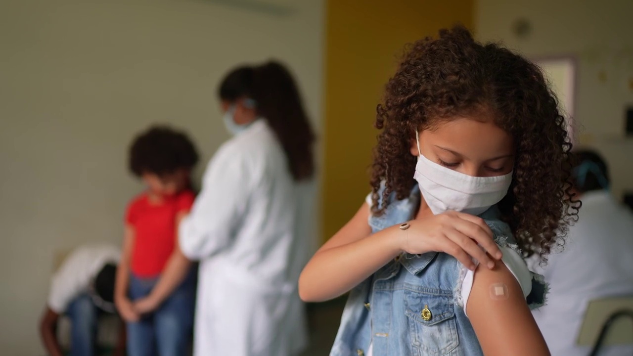 接种疫苗后，一个小女孩展示她的手臂的肖像视频素材
