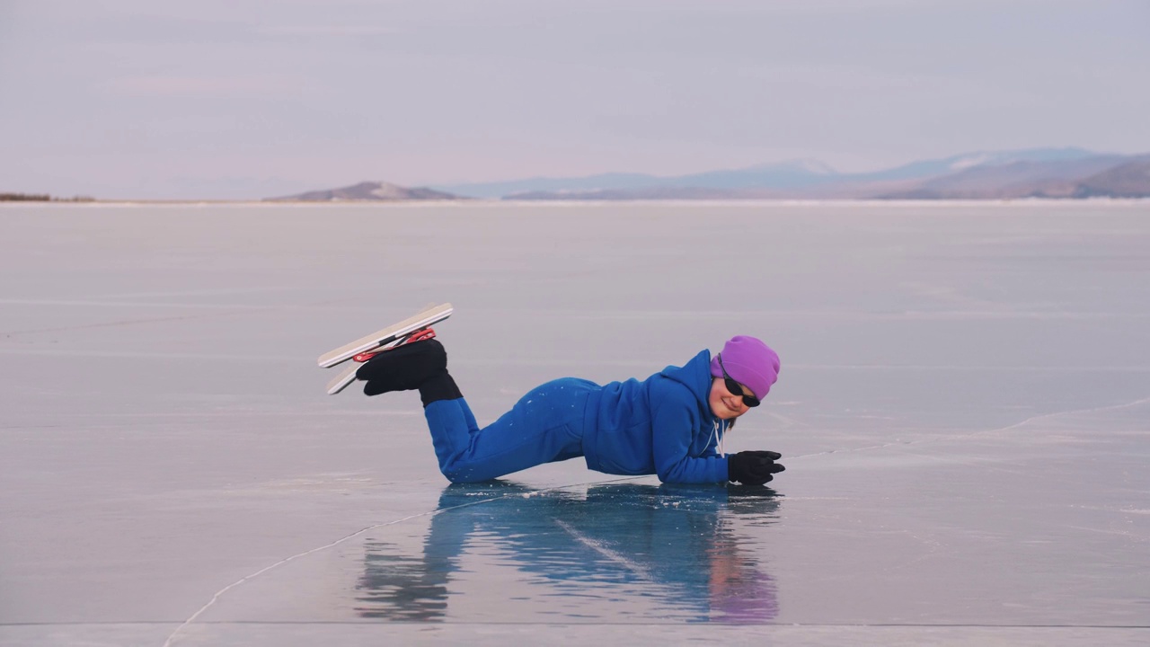 孩子们在冰上进行速滑训练。运动员伸展身体，热身，休息。那个小女孩穿着运动服，戴着运动眼镜溜冰。户外慢动作视频下载