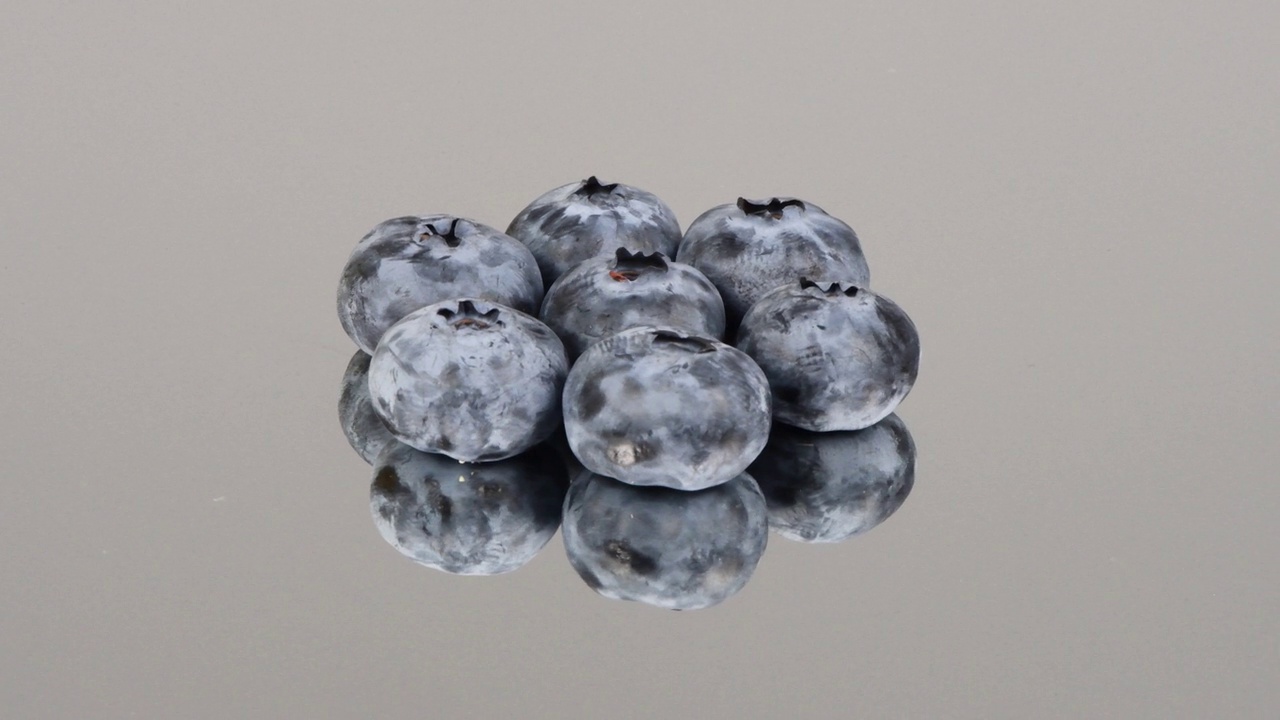 镜子上的七个蓝莓。侧视图。循环运动。旋转360。视频素材
