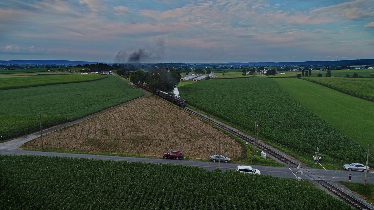 一辆古董蒸汽客运火车在宾夕法尼亚州的农田里吹着烟雾的鸟瞰图视频素材