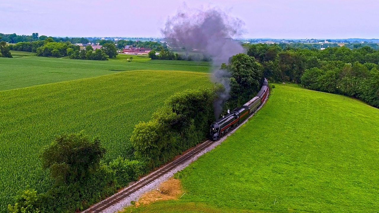 从空中俯瞰，一辆古董蒸汽客运火车在宾夕法尼亚的农田里吹着黑烟视频素材