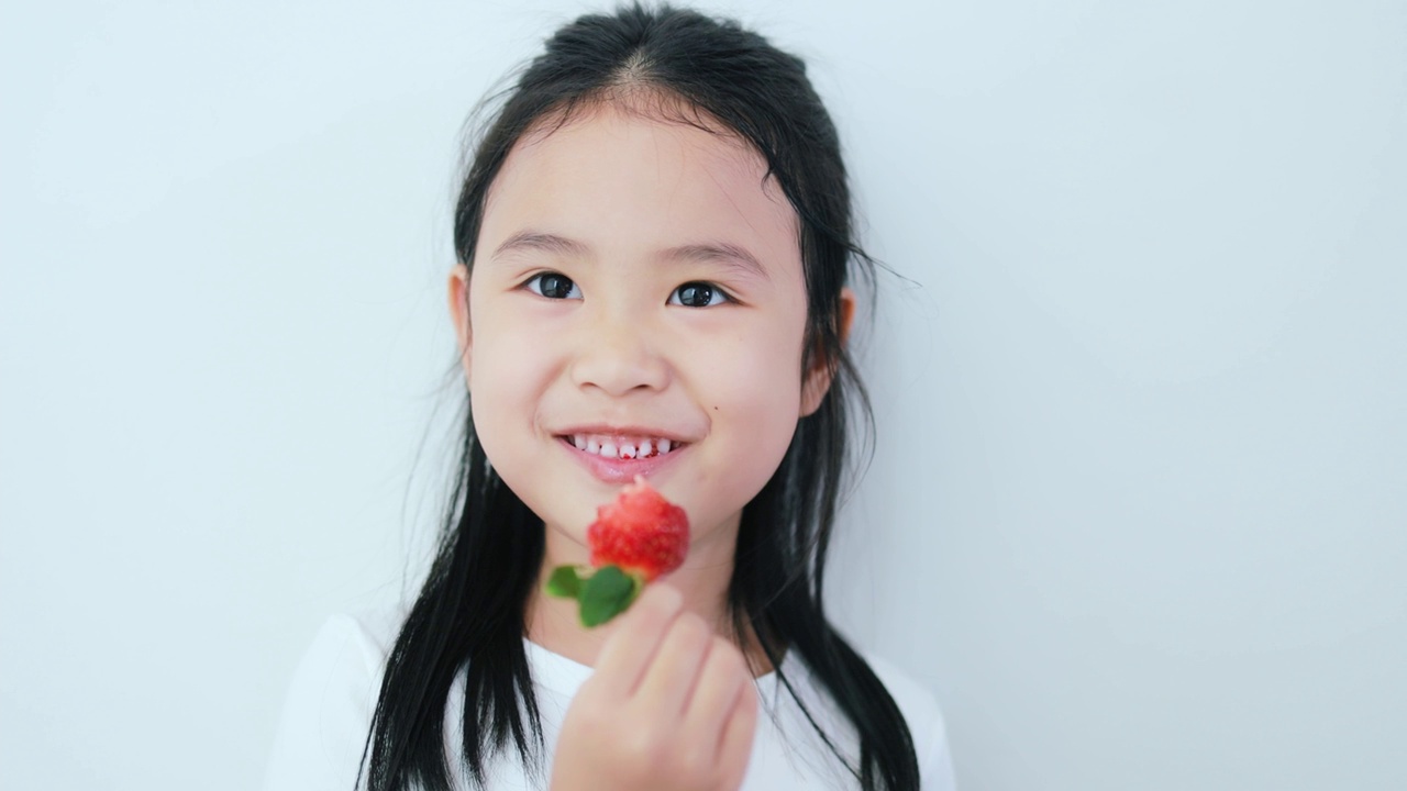 吃草莓的亚洲女孩。视频下载