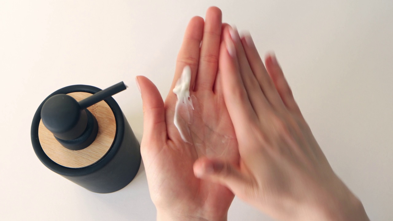 女性手部皮肤护理。女人在涂护手霜，特写镜头。保湿敏感肌肤，4k视频下载