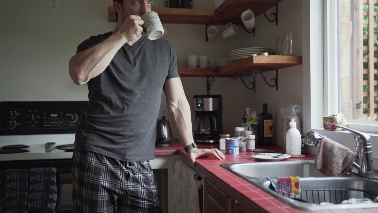 早上站在厨房里喝咖啡的男人视频素材