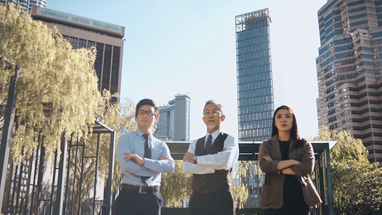 亚洲中国公司的首席执行官和他的团队在早上站在城市的办公大楼的屋顶交叉手臂望向别处视频下载