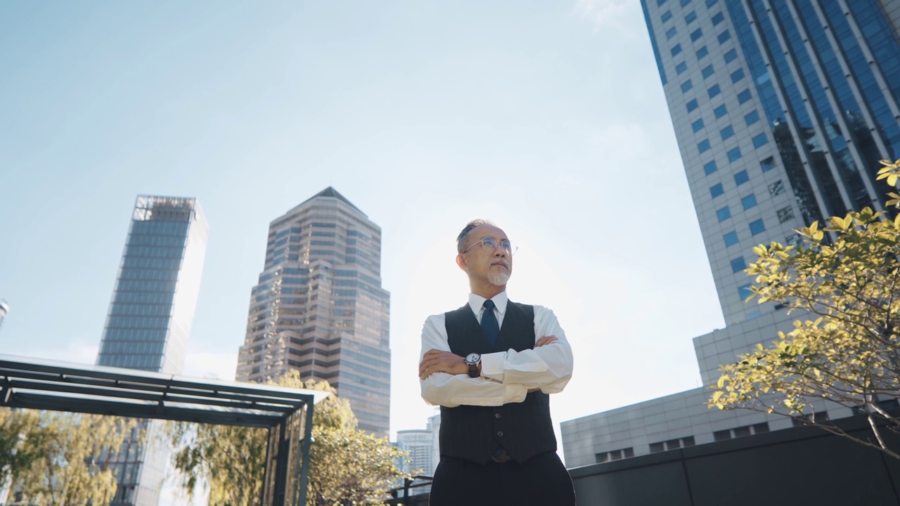 亚洲中国公司首席执行官双臂交叉站在城市办公楼的屋顶上，上午望向别处视频下载
