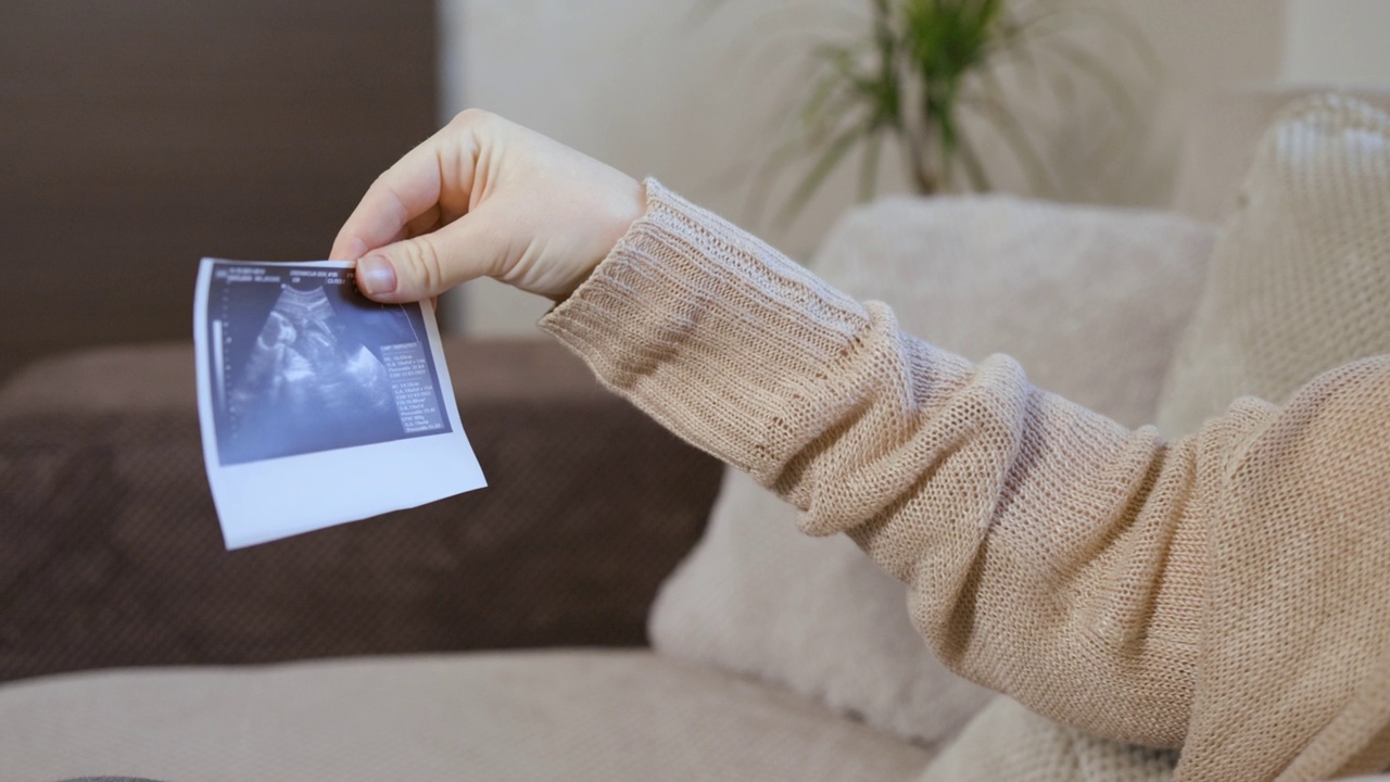 快乐怀孕女性看超声波扫描照片视频下载