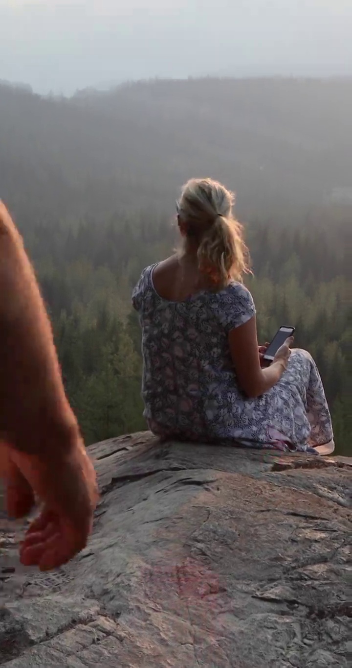 一对情侣在悬崖边观看日出，下面是森林视频素材