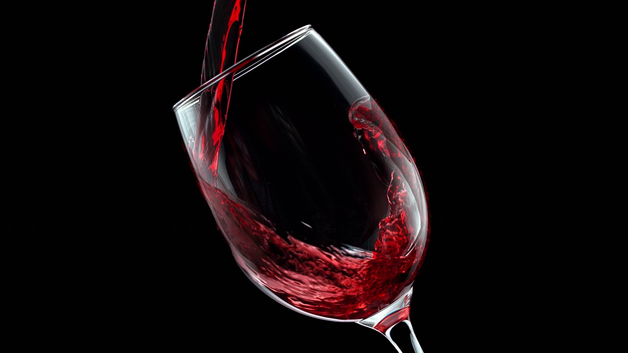 红酒在黑色背景的水晶酒杯中倾倒和旋转，慢动作1000帧/秒视频素材