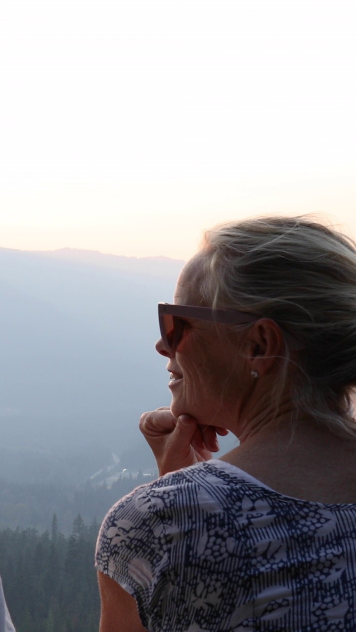 一名女子在俯瞰山脉的窗台上放松视频素材