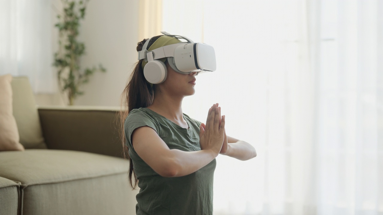 戴着虚拟现实眼镜的女人正在冥想，享受模拟和在家放松视频下载