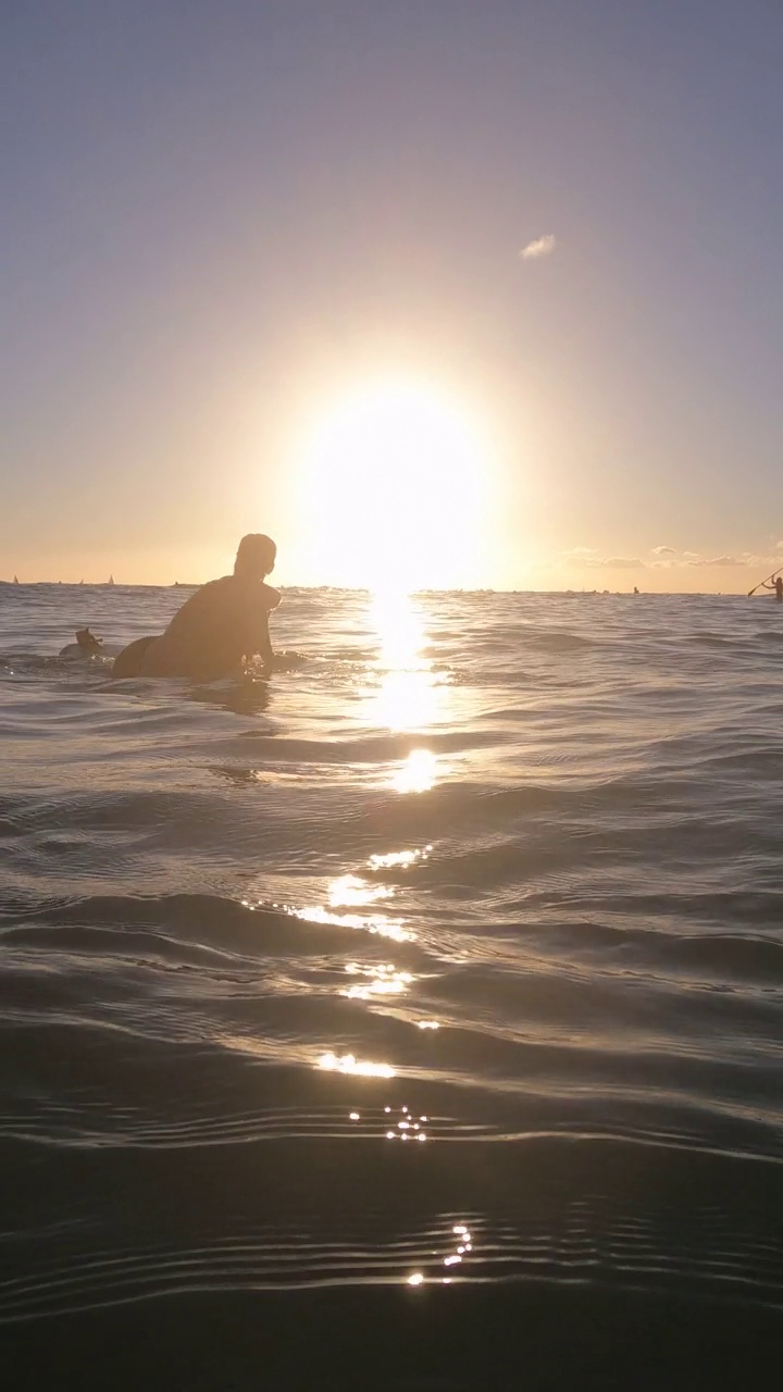在夏威夷瓦胡岛的怀基基，一名女子坐在钻石岬附近的冲浪板上。- - - - - -垂直格式视频素材