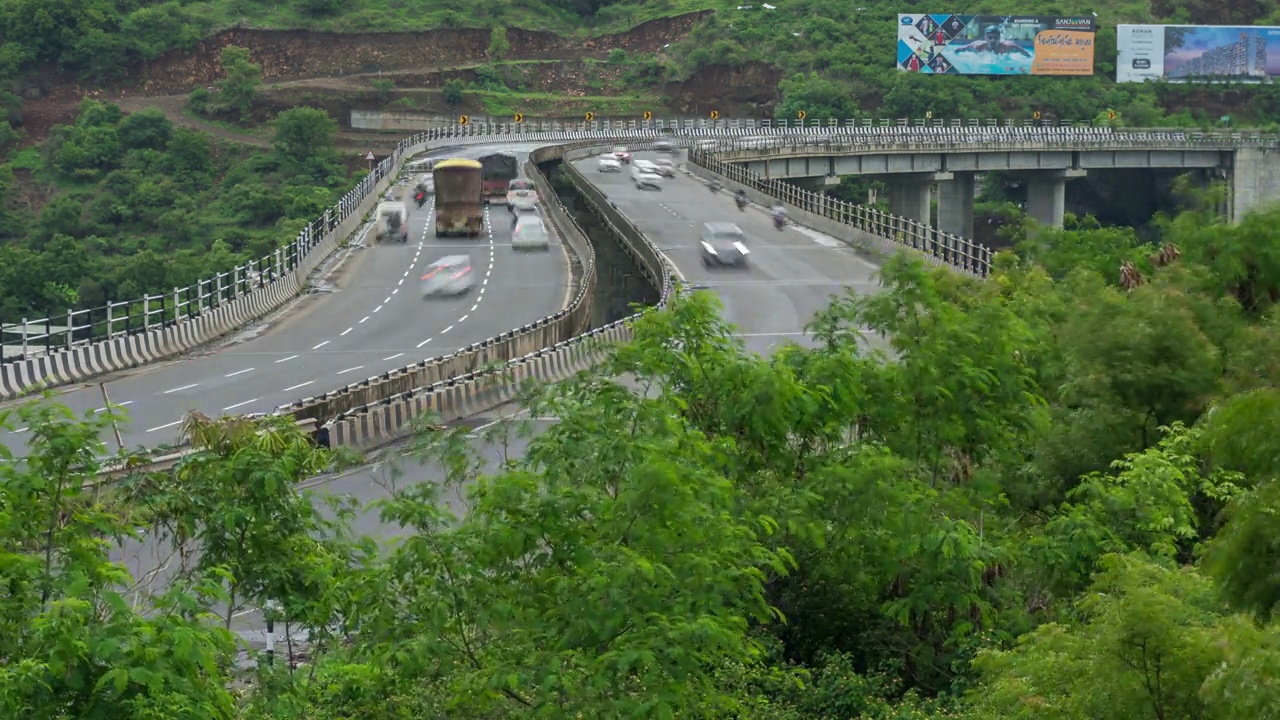 繁忙的交通经过孟买-浦那-班加罗尔弯曲的国家公路，浦那，马哈拉施特拉邦，印度视频下载