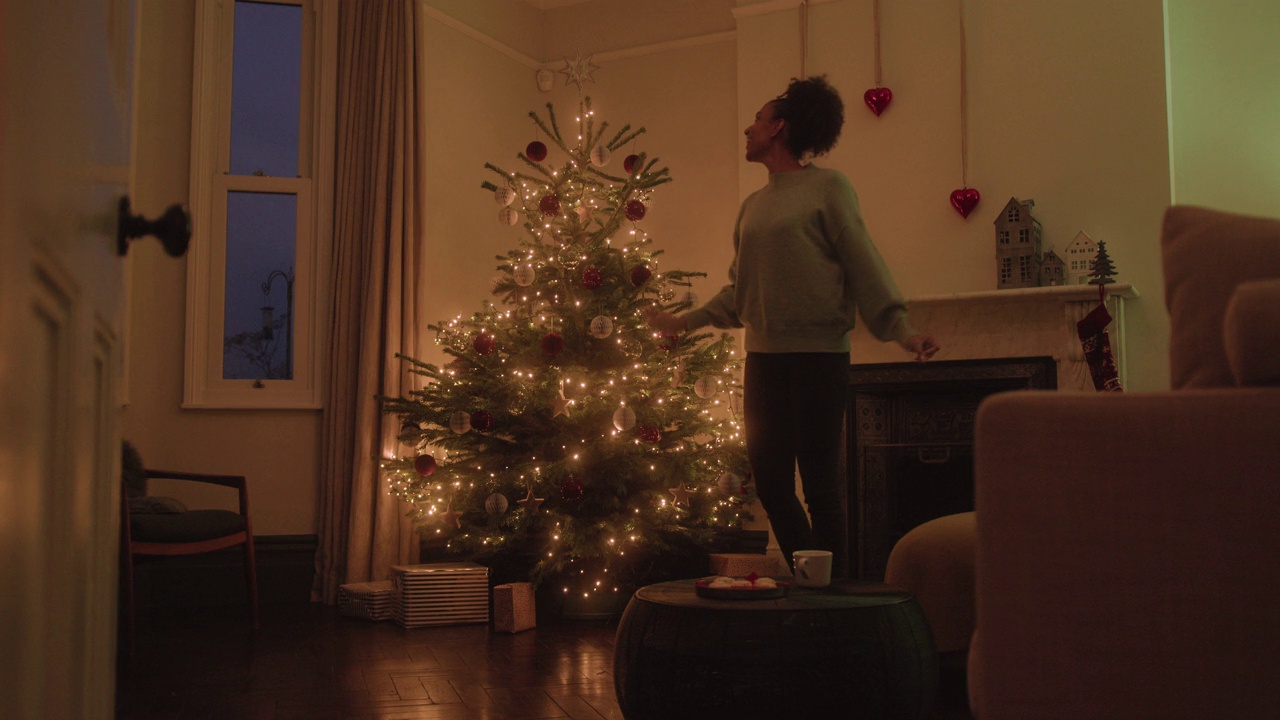 独自在家装饰圣诞树和跳舞的女人视频下载