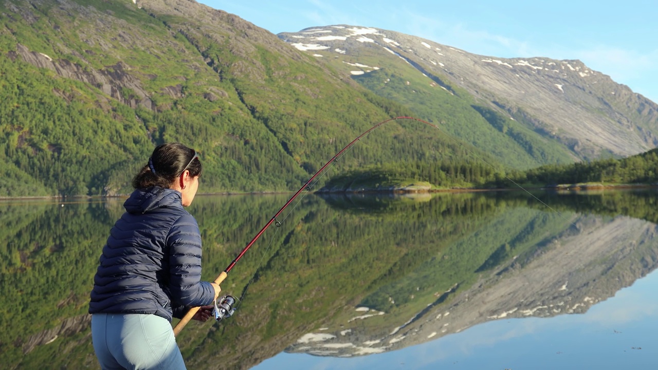 挪威，一名妇女在钓鱼杆上打转。视频素材