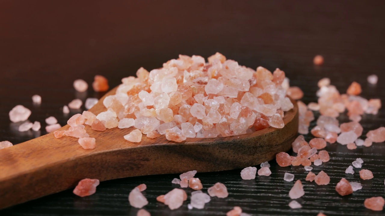 喜玛拉雅粉红色的盐在一个木制被用来调味食物。主要由于营销成本，粉色喜马拉雅盐比普通食盐或海盐贵20倍。视频素材