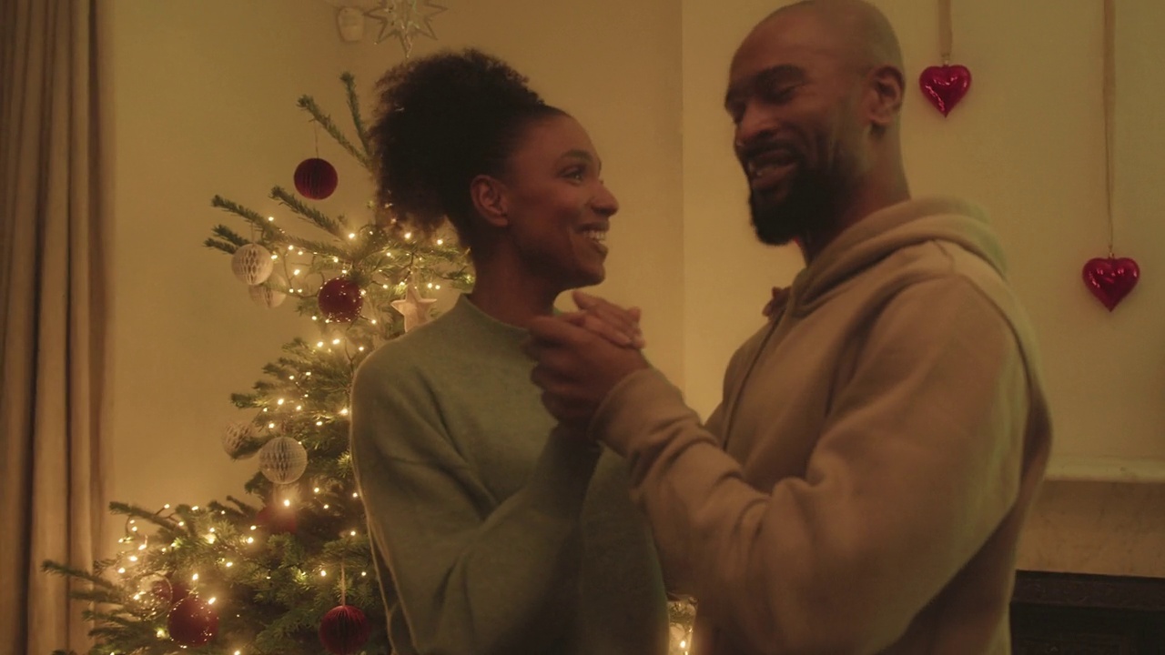 节日期间，在家里的圣诞树前跳舞的情侣视频下载