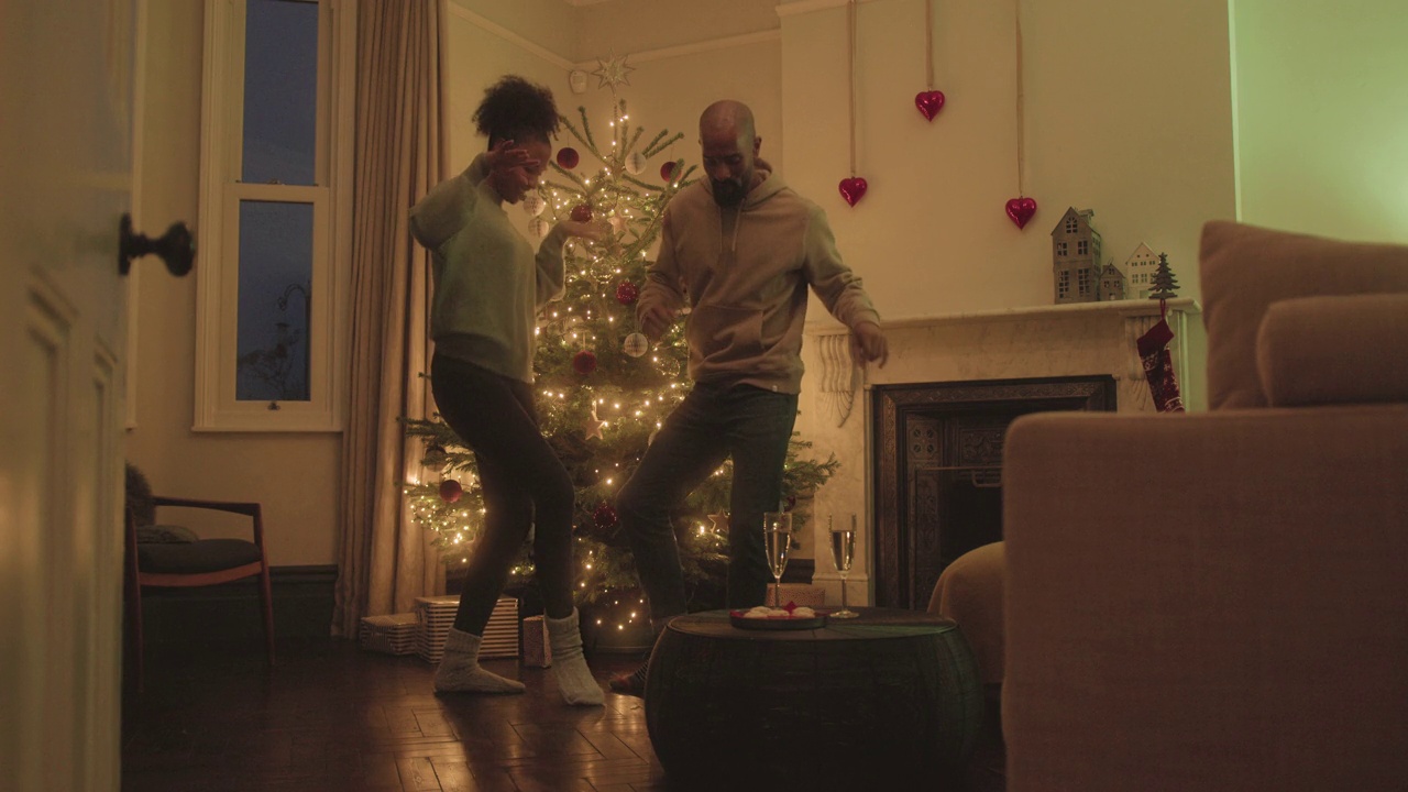 节日期间，在家里的圣诞树前跳舞的情侣视频下载