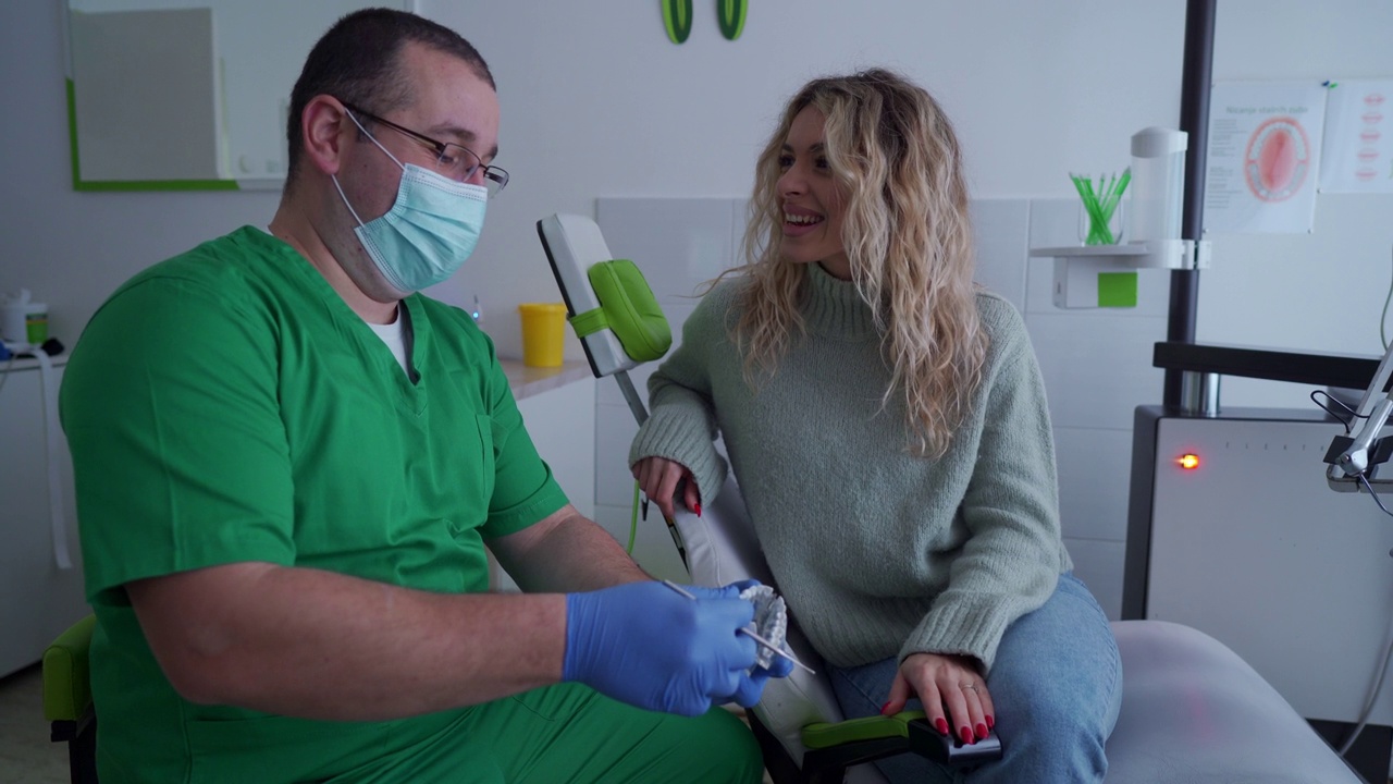 牙医向他的女病人展示如何正确清洁牙齿视频下载