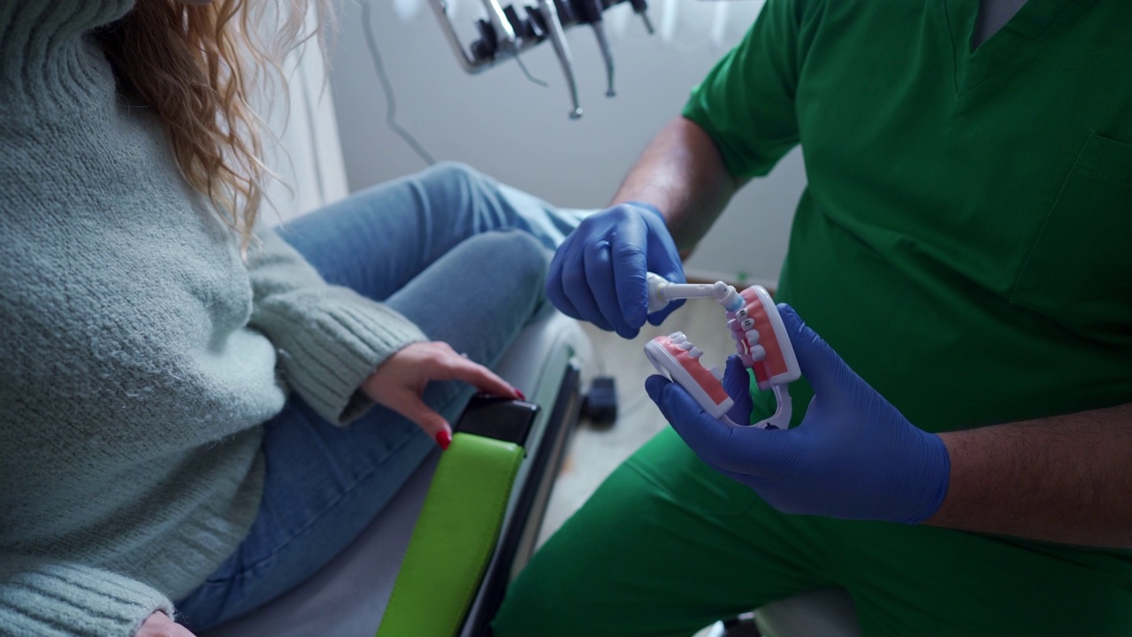 男牙医向他的女病人展示如何正确洗牙视频下载