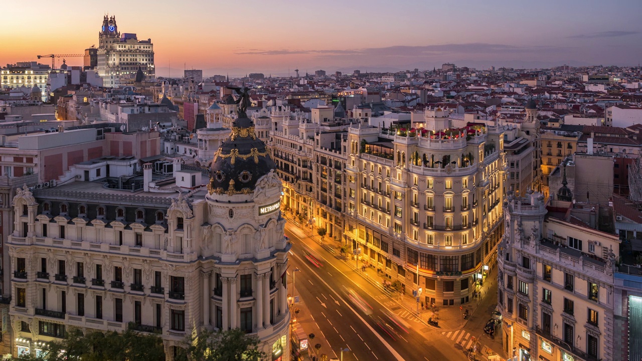 西班牙马德里市中心，Gran Via街道上的交通和历史建筑日落时的时间推移视图视频下载